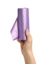 Woman holding roll of violet garbage bags on white background, closeup. Cleaning supplies