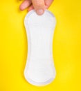 Woman is holding sanitary napkin in hand on yellow Royalty Free Stock Photo