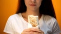 Woman holding shawarma, cheap delicious but unhealthy food, addiction