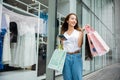 woman holding shopping bag and smartphone on her hands near the mall shop window Royalty Free Stock Photo