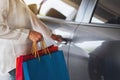 A woman holding shopping bags while opening car door in the mall parking lot Royalty Free Stock Photo