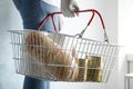 Woman holding shopping basket with products and toilet paper rolls indoors. Panic caused by virus Royalty Free Stock Photo