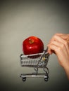 Woman holding shopping cart with apple inside Royalty Free Stock Photo