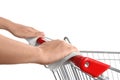Woman holding shopping cart handle with tissue papers on background, closeup Royalty Free Stock Photo
