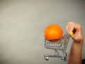 Woman holding shopping cart with orange inside Royalty Free Stock Photo