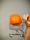 Woman holding shopping cart with orange inside Royalty Free Stock Photo