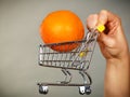 Woman holding shopping cart with orange inside Royalty Free Stock Photo