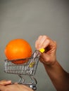 Woman holding shopping cart with orange inside Royalty Free Stock Photo