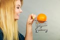 Woman holding shopping cart with orange inside Royalty Free Stock Photo