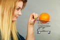 Woman holding shopping cart with orange inside Royalty Free Stock Photo