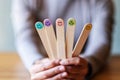 A female holding and showing colorful hand draw happy emotion faces on wooden stick