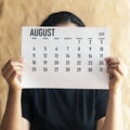 A woman holding simple August 2019 calendar