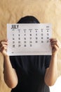 A woman holding simple July 2019 calendar