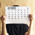 A woman holding simple October 2019 calendar