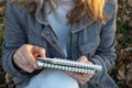 Woman in holding sketchbook and a pencil outdoors. Close-up of hands with notebook and pencil. Drawing, writing, learning