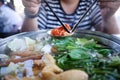 Woman holding sliced beef meat by chopsticks shabu shabu is Korean or Japanese style beef in hot pot dish of thinly sliced meat an Royalty Free Stock Photo