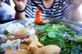 Woman holding sliced beef meat by chopsticks shabu shabu is Korean or Japanese style beef in hot pot dish of thinly sliced meat an Royalty Free Stock Photo