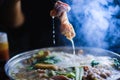 Woman holding sliced beef meat by chopsticks shabu shabu is Korean or Japanese style beef in hot pot dish of thinly sliced meat an Royalty Free Stock Photo