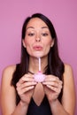 Woman holding a small pink birthday cake