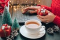 Woman holding small present box in hand and using search by laptop. Christmas Concept. Online shopping. Holiday sale Royalty Free Stock Photo