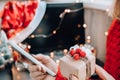 Woman holding small present box in hand and using search by laptop. Christmas Concept. Online shopping. Holiday sale Royalty Free Stock Photo