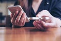 A woman holding smart phone while playing fidget spinner