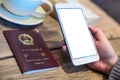 Woman holding a smartphone with a chinese passeport Royalty Free Stock Photo