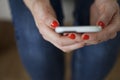 Woman Holding Smartphone with Coral Nails