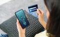 Woman holding smartphone and credit card with scanning biometric fingerprint for approval to access for payment mobile.