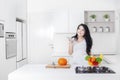 Woman holding smartphone in kitchen Royalty Free Stock Photo