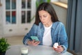 Woman holding a smartphone and pills container