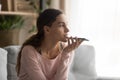 Woman holding smartphone using virtual assistant or talk on speakerphone Royalty Free Stock Photo