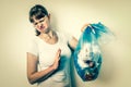 Woman holding a smelly garbage bag - retro style