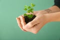 Woman holding soil with green plant in hands on color background, closeup. Ecology concept Royalty Free Stock Photo