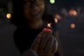 Woman holding sparkler at festival celebration ,evening