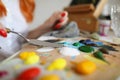 Woman holding a spatula over a palette with paints