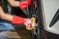 Woman holding sponge washing the wheels of car Royalty Free Stock Photo