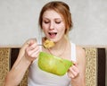 Woman is holding a spoonful of fruit salad