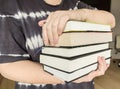 Woman holding a stack of books in her hands Royalty Free Stock Photo
