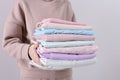 Woman holding stack of clean bed linens on light background, closeup Royalty Free Stock Photo