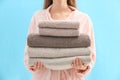 Woman holding stack of fresh clean towels on blue background, closeup Royalty Free Stock Photo