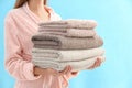 Woman holding stack of fresh clean towels on blue background, closeup Royalty Free Stock Photo