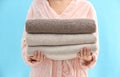 Woman holding stack of fresh clean towels on light blue background, closeup Royalty Free Stock Photo