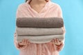 Woman holding stack of fresh clean towels on light blue background, closeup Royalty Free Stock Photo