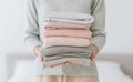 A woman is holding a stack of towels in her hands by AI generated image Royalty Free Stock Photo