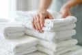 A woman is holding a stack of white towels by AI generated image Royalty Free Stock Photo