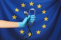 Woman holding stethoscope against flag of European Union, closeup Royalty Free Stock Photo