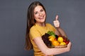 Woman holding straw basket with summer vegetables giving thumb u Royalty Free Stock Photo