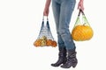 Woman holding string bags with yellow fruits Royalty Free Stock Photo