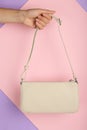 Woman holding stylish beige bag on color background, closeup Royalty Free Stock Photo